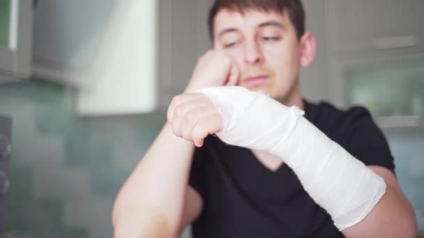 Перелом руки. Ограничения здоровья. Грустный человек со сломанной рукой — стоковое видео