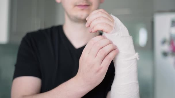 Comichão sob curativo. Homem tenta arranhar braço quebrado, close-up — Vídeo de Stock