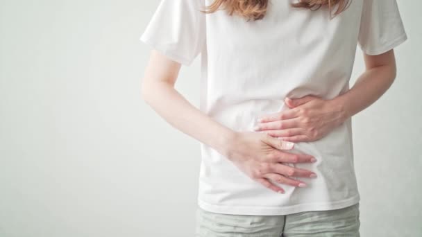 En kvinna håller fast vid magen under sin mens. Magont. Kvinnors hälsa cykel, gynekologi — Stockvideo