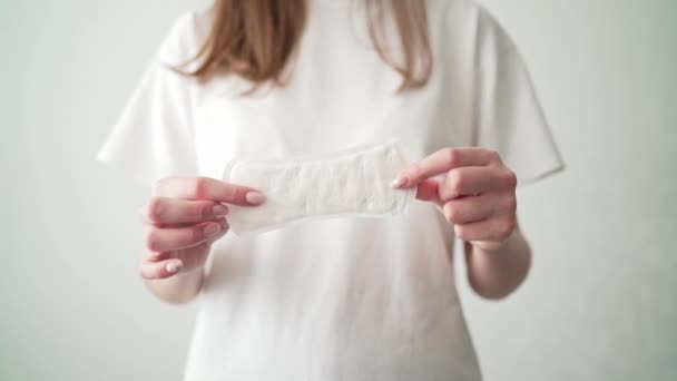 En kvinna med mens har en vit binda. Ta hand om kvinnors hälsa. Hygien under menstruation — Stockvideo