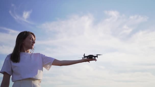 Fata este un pilot de drone care deține o dronă de lucru pe mână la apusul soarelui. Elicele de lucru ale unui mic quadcopter în mâinile femeilor — Videoclip de stoc