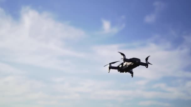 Un petit drone planait dans le ciel au coucher du soleil, contre les nuages. Photographie aérienne professionnelle — Video