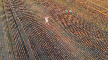 Uçurtma manzaralı. Bir kadın buğday tarlasında rüzgarda uçurtma fırlatıyor.
