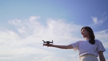 Kadın dronu avucunun içinden fırlatıyor. Gökyüzüne karşı kuadkopteri kaldırmak, değişen odak
