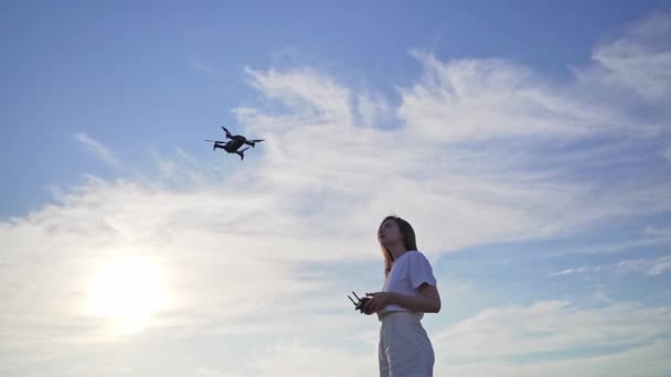 En kvinna lär sig att kontrollera en drönare. Utbildning för att flyga på en quadcopter på en säker plats — Stockvideo