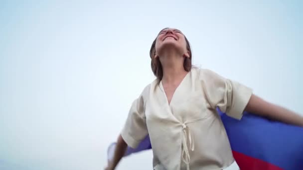 Kobieta z rosyjską flagą krzyczy i świętuje zwycięstwo w zawodach. Podekscytowany rosyjski cute kobieta przed niebem — Wideo stockowe
