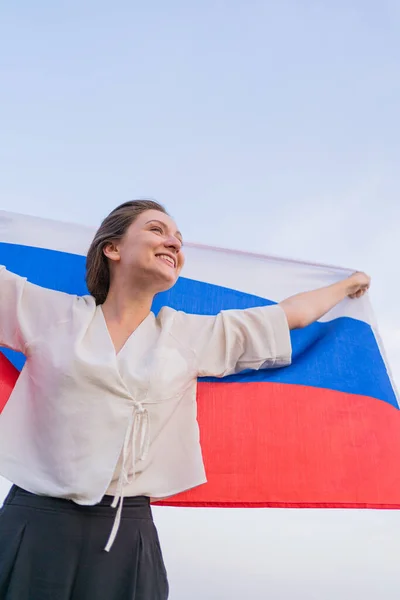 Mulher com bandeira da Federação Russa contra o céu azul. Dia da independência das Rússias — Fotografia de Stock
