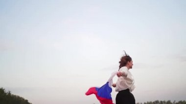 Rusya bayrağı taşıyan bir kadın doğada koşar. Mutluluk ve vatanseverlik, Rusya Federasyonu bayrağı sallama