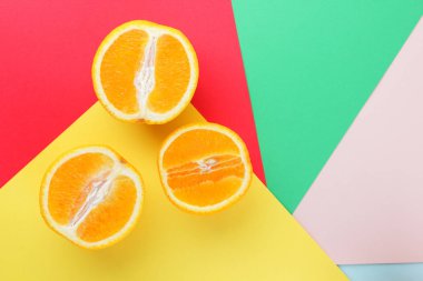 Meyve portakal renkli bir arka plan üzerinde yarım portakal renkli kağıt üzerinde. Uzay kopyalayın. Pop sanat tarzı narenciye