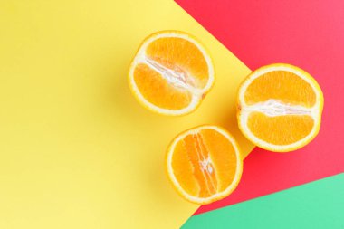 Meyve portakal renkli bir arka plan üzerinde yarım portakal renkli kağıt üzerinde. Pop sanat tarzı narenciye