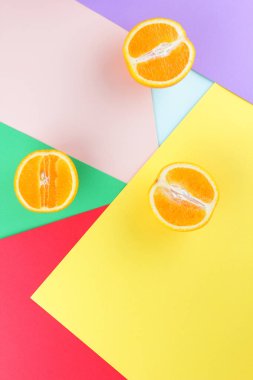 Meyve portakal renkli bir arka plan üzerinde yarım portakal renkli kağıt üzerinde. Pop sanat tarzı narenciye