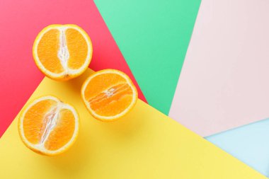 Meyve portakal renkli bir arka plan üzerinde yarım portakal renkli kağıt üzerinde. Pop sanat tarzı narenciye