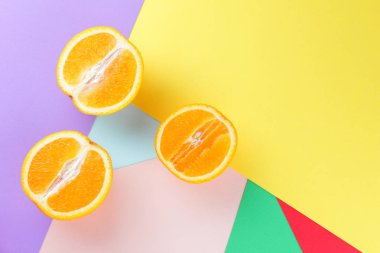 Meyve portakal renkli bir arka plan üzerinde yarım portakal renkli kağıt üzerinde. Pop sanat tarzı narenciye