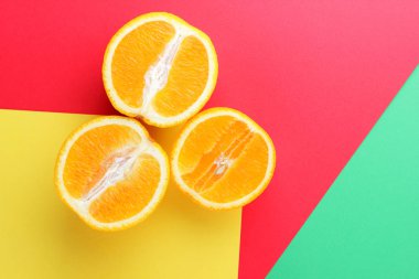 Meyve portakal renkli bir arka plan üzerinde yarım portakal renkli kağıt üzerinde. Pop sanat tarzı narenciye