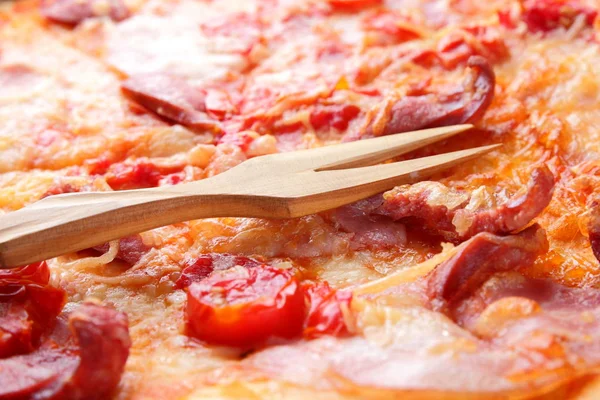 Pizza close-up, Italian pizza with bacon, tomatoes, sausages and cheese, appetizing pastry top view, baked cheese cake with meat, delicious lunch, designer\'s preparation