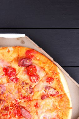 Siyah ahşap arka plan, domates, pastırma, sosis ve peynir, Lokanta, karanlık bir arka plan kopya alanı Festival gıda ile İtalyan pizza pizza