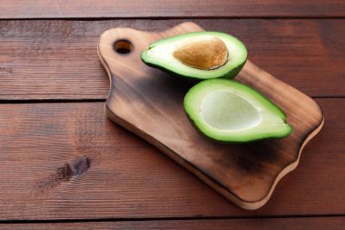Avokado üzerinde eski bir ahşap masa, avokado yarım ahşap arka plan, yeşil tropikal meyve en iyi görünüm, vintage bir arka plan üzerinde egzotik meyve üzerinde alan, etiket için boş kopyalama