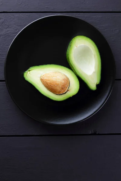 Avocat Sur Une Assiette Noire Moitiés Avocat Sur Fond Bois — Photo