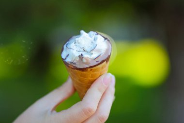 Dondurma koni elinde, çikolatalı dondurma arka plan bulanık, süt tatlı yaz tatili, tasarımcı için kopya alanı boş üzerinde