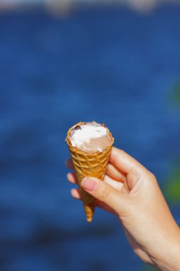 Dondurma koni elinde, çikolatalı dondurma arka plan bulanık, süt tatlı yaz tatili, tasarımcı için kopya alanı boş üzerinde