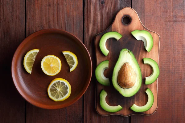 Avokado ahşap tahta üstte görüntülemek, avokado ve limon ahşap panoları, Vejetaryen gıda, sağlıklı Asya gıda, tropik meyveler kahvaltıda dilimlenmiş, alanı Kopyala