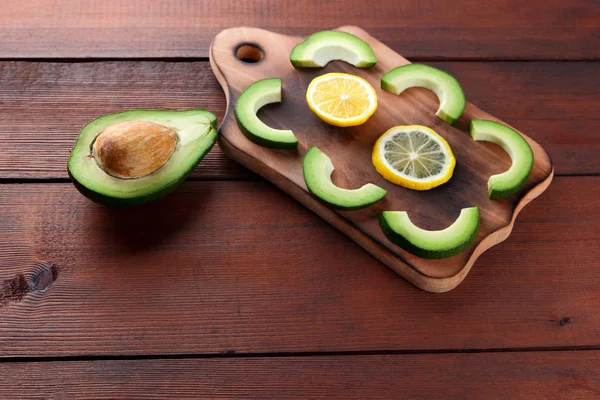 Avokado ahşap tahta üstte görüntülemek, avokado ve limon ahşap panoları, Vejetaryen gıda, sağlıklı Asya gıda, tropik meyveler kahvaltıda dilimlenmiş, alanı Kopyala