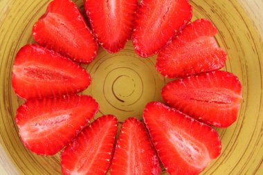 Sarı bir tabak, çizgili kırmızı çilek yarım daire üstten görünüm, beyaz bir arka planda, vejetaryen yemek kahvaltı için kırmızı çilek çilek kopyalama alanı, sağlıklı gıda, diyet