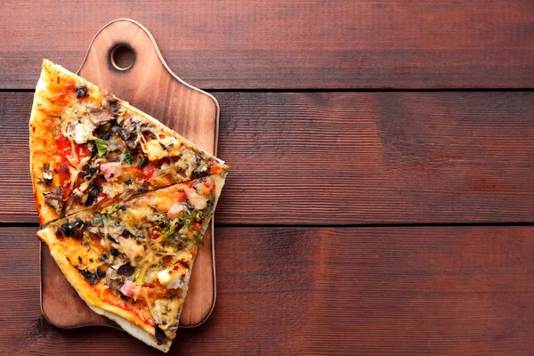 Pizza slices on a wooden board, Italian pizza on a wooden background top view, Italian food, appetizing dish for summer vacation, American food, copy space
