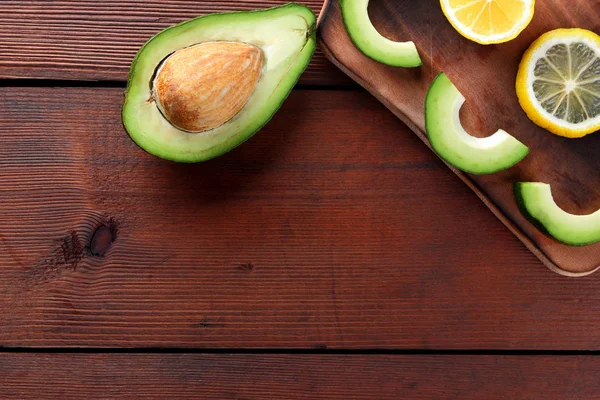 Ahşap tahta üstten görünüm, avokado ve limon ahşap panoları, Vejetaryen gıda, sağlıklı Asya gıda, dilimlenmiş üzerinde avokado tropikal meyveler Kahvaltı, Meksika yemeği, kopya alanı için