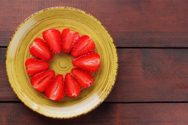 Alan, bir tasarımcı için yaratıcı boş ahşap kurullarında, yarısı bir daire, vejetaryen yemek kahvaltı için sarı bir tabakta kırmızı meyveler şeklinde kırmızı çilek çilek kopyalama