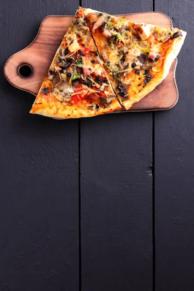 Pizza slices on a wooden board, Italian pizza with chicken and mushrooms on a dark wooden background, dish with cheese and meat with copy space, appetizing lunch view from above, vintage style, art