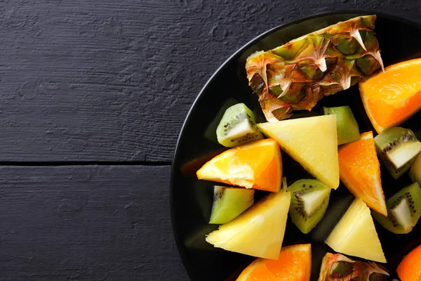 Fruit Salad Black Plate Wooden Boards Pineapples Oranges Kiwi Dark — Stock Photo, Image
