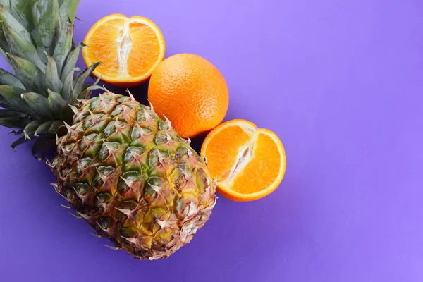 Ananas Sinaasappels Een Paarse Achtergrond Citrus Bovenaanzicht Ananas Helften Van — Stockfoto