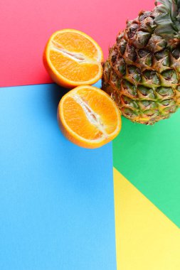 Ananas ve portakal renkli bir arka plan üzerinde tropikal meyve görünümü, ananas ve portakal pop sanat tarzı, vejetaryen yemek minimalizm tarzı, kopya alanı yarısı top