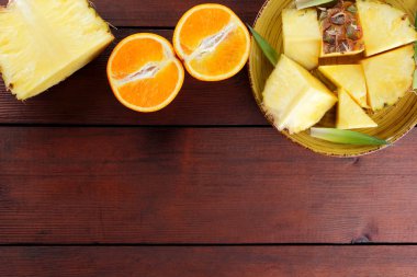 Ananas ve portakal ahşap panoları, ananas ve portakal ahşap zemin, kahvaltıda vejetaryen yemek, tropikal meyve salatası yarısı sarı bir tabakta alanı Kopyala