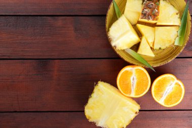 Ananas ve portakal ahşap panoları, ananas ve portakal ahşap zemin, kahvaltıda vejetaryen yemek, tropikal meyve salatası yarısı sarı bir tabakta alanı Kopyala