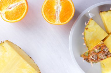 Ananas ve portakal beyaz bir tabak, ananas ve turuncu beyaz arka plan en iyi görünüm, kahvaltıda vejetaryen yemek, narenciye salatası yarısı alanı Kopyala