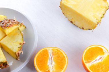 Ananas ve portakal beyaz bir tabak, ananas ve turuncu beyaz arka plan en iyi görünüm, kahvaltıda vejetaryen yemek, narenciye salatası yarısı alanı Kopyala
