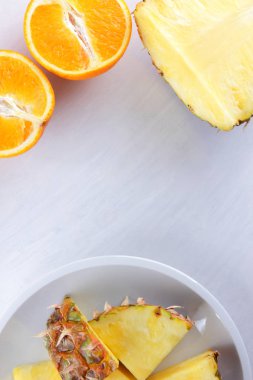Ananas ve portakal beyaz bir tabak, ananas ve turuncu beyaz arka plan en iyi görünüm, kahvaltıda vejetaryen yemek, narenciye salatası yarısı alanı Kopyala