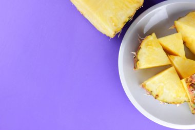 Bir beyaz tabak, mor bir arka plan üzerine kıyılmış taze ananas, kahvaltıda vejetaryen yemek, tropikal meyve salatası ananas parçaları alanı Kopyala