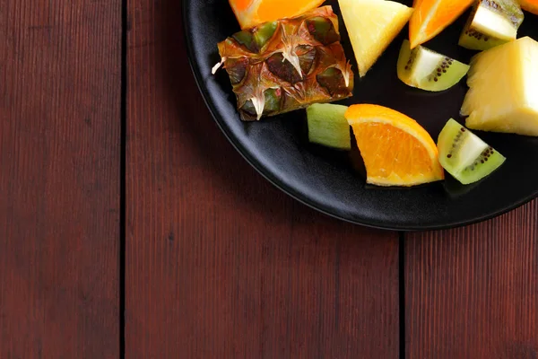 Obstsalat Für Veganer Ananasstücke Orangen Und Kiwi Auf Schwarzem Teller — Stockfoto