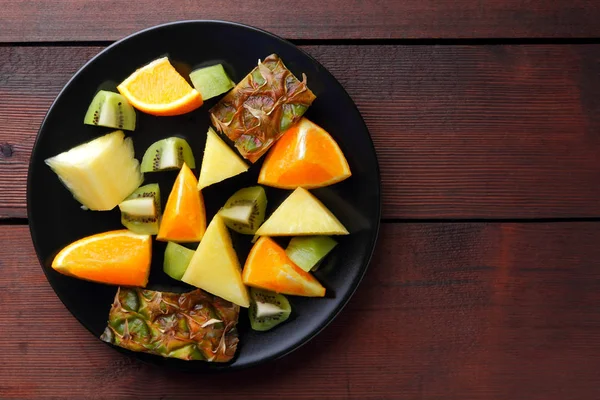 Fruit Salad Vegans Pieces Pineapple Oranges Kiwi Black Plate Tropical — Stock Photo, Image