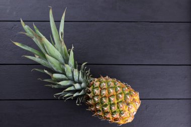 Ahşap panoları, ananas yapraklarda siyah arka plan ile kopya alanı, designer, vejetaryen yemek, meyve salatası hazırlama, sanat için boş olan tropikal meyve ananas