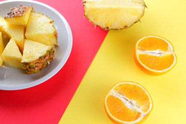 Beyaz bir tabak, kırmızı sarı zemin üzerine doğranmış ananas, kahvaltıda vejetaryen yemek pop art tropikal meyve salatası ananas parçaları