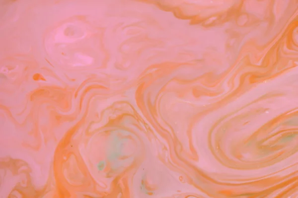 Orange abstract, pink orange stains on the liquid multicolored pattern, food colors in the milk, color pattern on the water, blank for the designer