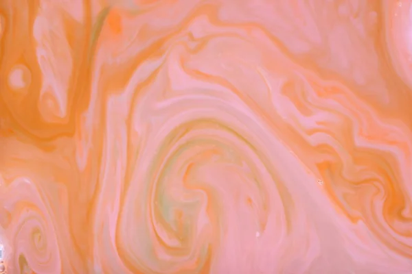 Orange abstract, pink orange stains on the liquid multicolored pattern, food colors in the milk, color pattern on the water, blank for the designer