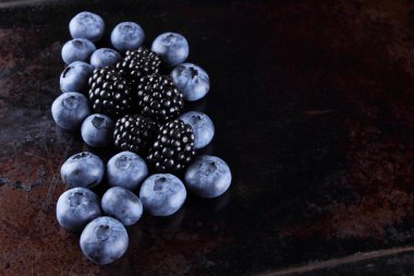 Yaban mersini ve böğürtlen koyu arka plan üzerinde vegan, paslı arka plan üzerinde meyve için taze çilek berry kahvaltı muhtelif