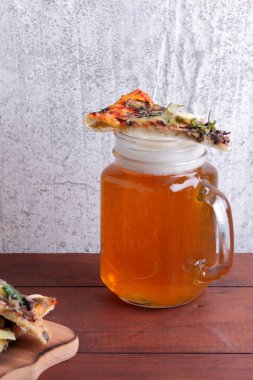 Bira ve pizza. Pizza dilimleri bir ahşap tahta üzerinde. Light bira ahşap arka plan üzerinde köpük bardak. En sevdiğim yemek erkekler için ayarla. Kopya alanı