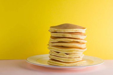 Krep pembe sarı bir arka plan üzerinde. Birçok krep kopya alanı ile beyaz tabakta. Pop sanat tarzı kahvaltı için lezzetli yemek. Festival gıda renkli arka plan üzerinde. Fransız kahvaltı