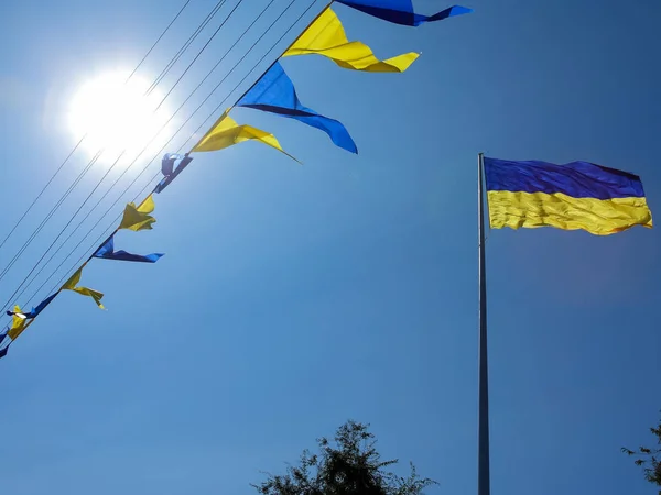 Ukrainian flag. Yellow-blue Ukrainian flag against the sky in the Dnipro. Ukraine\'s Independence Day. National symbol in the rays of the sun